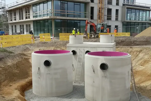 Ölabscheider aus Beton beim Einbau vor einem Gewerbegebäude